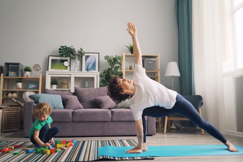 a woman and a child doing yoga in a living room